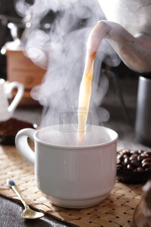 Téléchargez les photos : Une tasse de café fumante sur une table - en image libre de droit