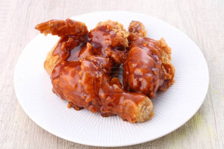 Photo for A plate of food with a chicken covered in sauce - Royalty Free Image