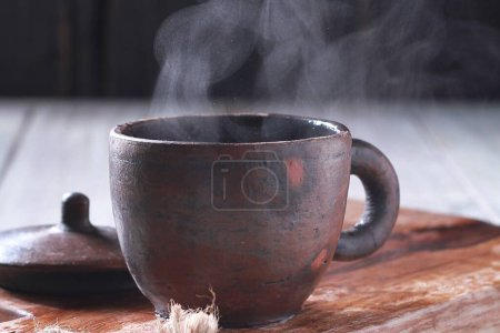 Téléchargez les photos : Une tasse de café fumante sur une table en bois - en image libre de droit
