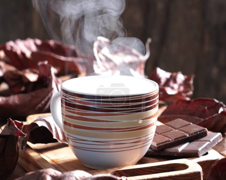 Téléchargez les photos : Une tasse de café sur une planche de bois avec des chocolats - en image libre de droit