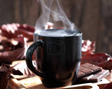 Téléchargez les photos : Une tasse de chocolat chaud avec une cuillère et une cuillère repose sur une planche à découper - en image libre de droit