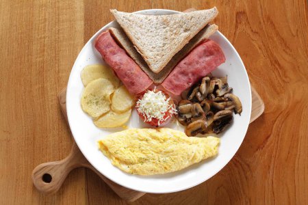 Photo for A plate of food with toast, ham, mushrooms, and bread - Royalty Free Image