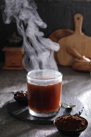 Téléchargez les photos : Une tasse de thé au chocolat chaud avec de la vapeur qui en sort - en image libre de droit
