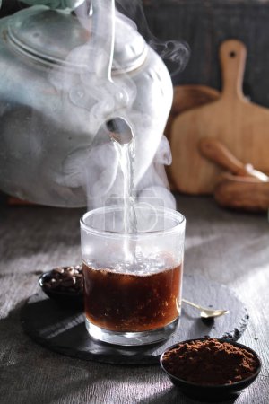 Téléchargez les photos : Une théière versant le thé dans un verre - en image libre de droit