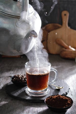 Photo for A tea pot pouring hot water into a cup - Royalty Free Image