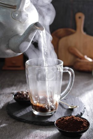 Foto de Una tetera que vierte agua en una taza - Imagen libre de derechos