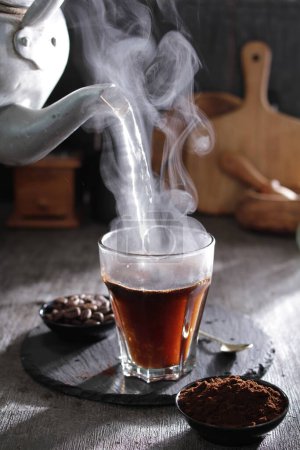 Téléchargez les photos : Une tasse de thé avec de la vapeur qui en sort - en image libre de droit
