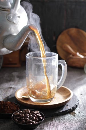 Téléchargez les photos : Une tasse de café versée dans un verre - en image libre de droit