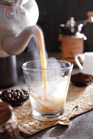 Téléchargez les photos : Une personne versant une tasse de café dans un verre - en image libre de droit