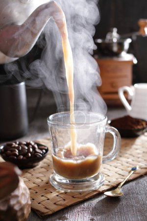 Photo for A cup of coffee being poured into a cup - Royalty Free Image