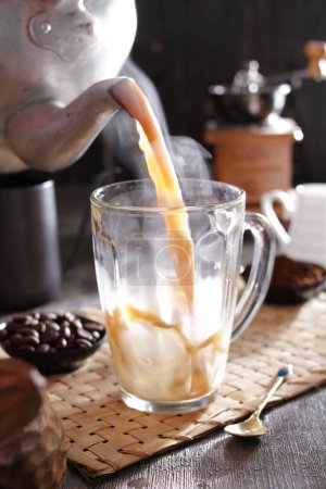 Téléchargez les photos : Une personne versant du café dans une tasse en verre - en image libre de droit