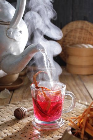 Téléchargez les photos : Une théière versant le thé dans une tasse - en image libre de droit