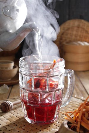 Téléchargez les photos : Une théière verse du thé dans un verre - en image libre de droit