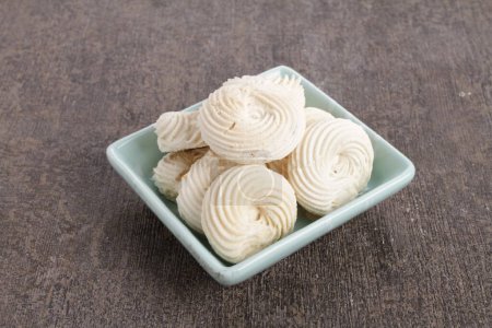 Foto de Un tazón de merengues blancos esmerilados sobre una mesa - Imagen libre de derechos