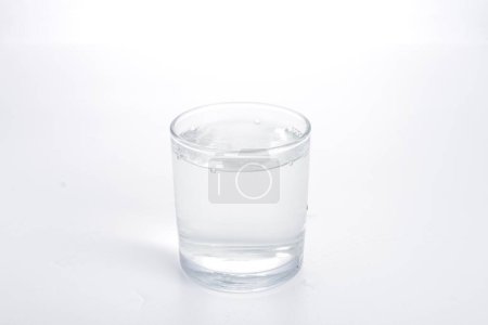 Téléchargez les photos : Un verre d'eau avec une petite quantité de glace - en image libre de droit