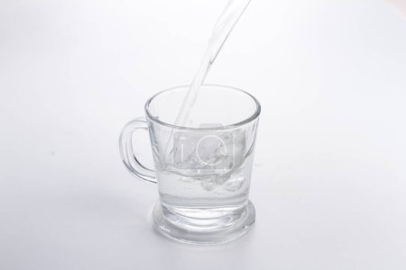 Téléchargez les photos : Un verre d'eau versé dans une tasse - en image libre de droit