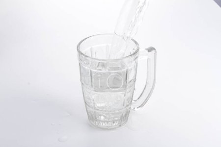 Téléchargez les photos : Un verre d'eau versé dans un pichet - en image libre de droit