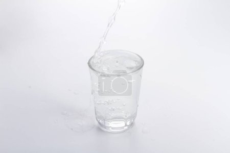 Foto de Un vaso de agua con una paja que se vierte - Imagen libre de derechos