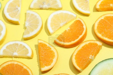 Photo for A yellow background with oranges, cucumber, and lemon slices - Royalty Free Image