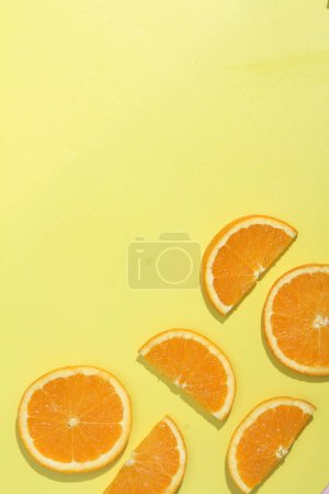 Foto de Un grupo de rodajas de naranja sobre una superficie amarilla - Imagen libre de derechos