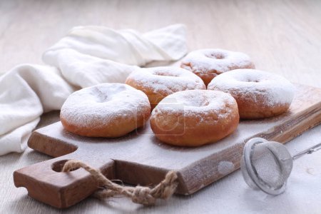 Photo for A wooden cutting board with doughnuts on it - Royalty Free Image