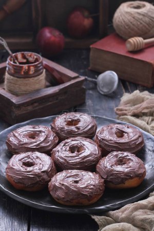Téléchargez les photos : Une assiette de beignets au chocolat avec un pot de pommes en arrière-plan - en image libre de droit