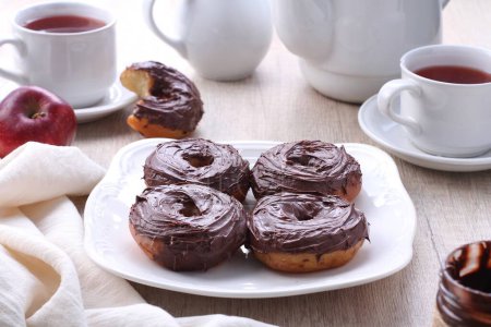 Photo for A plate of chocolate donuts with a cup of tea - Royalty Free Image