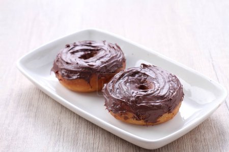 Photo for Two chocolate frosted donuts on a white plate - Royalty Free Image