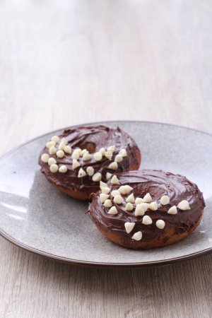 Téléchargez les photos : Deux beignets au chocolat avec glaçage au chocolat blanc sur une assiette - en image libre de droit