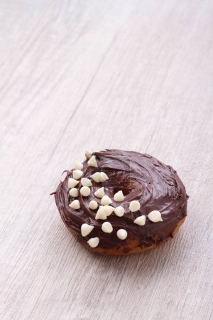 Photo for A chocolate frosted donut with white sprinkles - Royalty Free Image