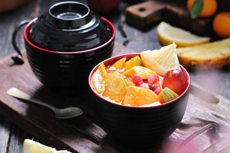Foto de Un tazón de fruta con una cuchara y una tetera - Imagen libre de derechos