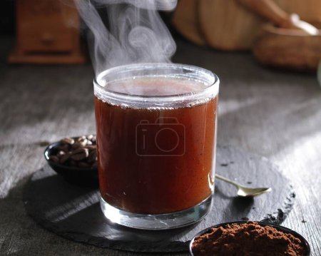 Photo for A cup of hot tea with a spoon of cocoa powder - Royalty Free Image