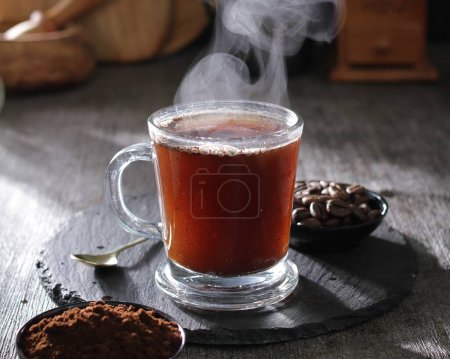 Photo for A cup of hot tea with a spoon and spoon rest on a table - Royalty Free Image