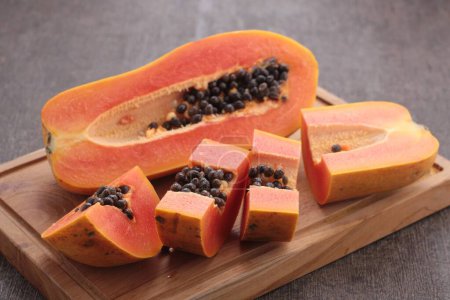 Téléchargez les photos : Fruits de papaye tranchés sur un fond en bois - en image libre de droit
