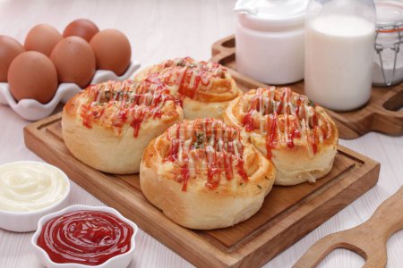 Photo for Tasty buns with cheese, eggs and ketchup on wooden table, closeup - Royalty Free Image