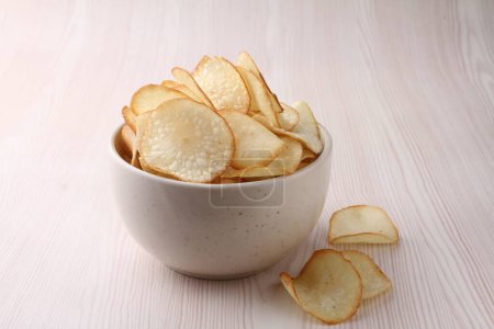 Photo for Potato chips with salt and garlic on a wooden board on the table - Royalty Free Image