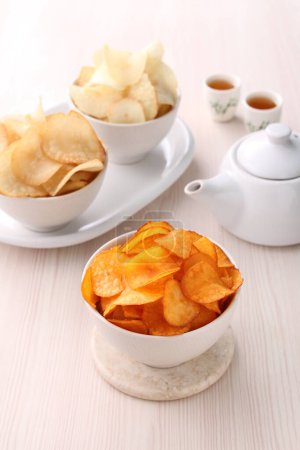 Photo for Bowl with delicious potato chips and sauce on white table, closeup - Royalty Free Image