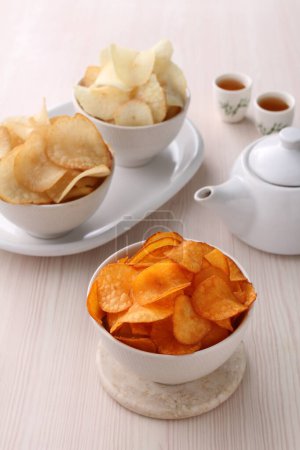 Photo for Potato chips on the white plate with tea - Royalty Free Image