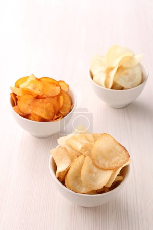 Photo for Plate with chips of potatoes and potato on white background - Royalty Free Image
