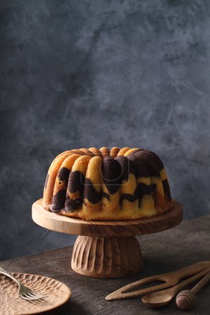 Téléchargez les photos : Gâteau de Pâques fait maison avec un glaçage et cannelle sur un fond en bois - en image libre de droit