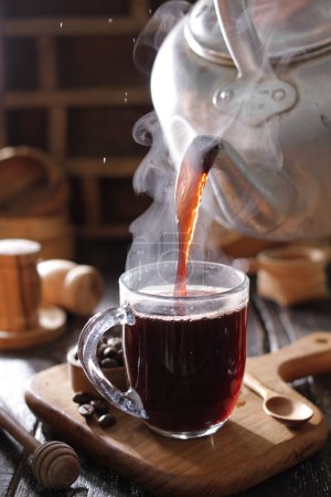 Téléchargez les photos : Café chaud avec fumée et épices en fond de bois - en image libre de droit
