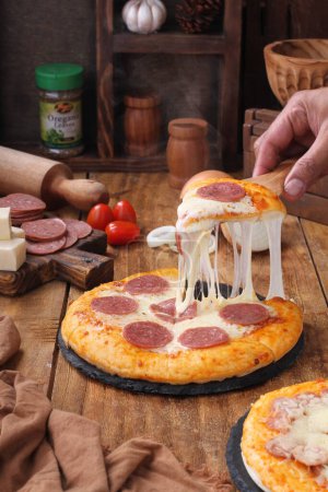 Foto de Pizza con salchicha y queso sobre un fondo de madera - Imagen libre de derechos