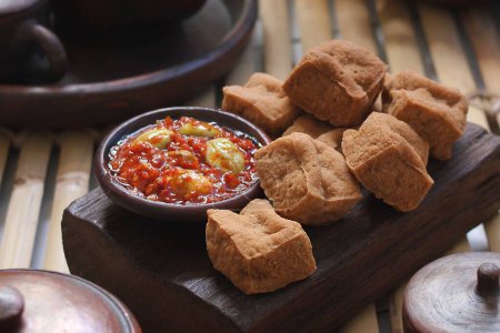 Téléchargez les photos : Tofu frit salé et délicieux servi avec sauce chili à l'ail et pétai - en image libre de droit