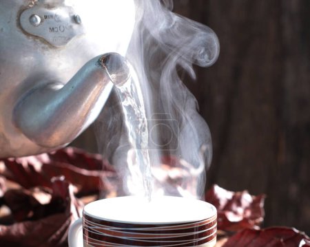 Téléchargez les photos : Une tasse de thé et une théière sur une table en bois - en image libre de droit