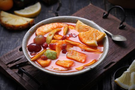 Téléchargez les photos : Bol avec soupe de fruits sucrés savoureux sur fond sombre - en image libre de droit