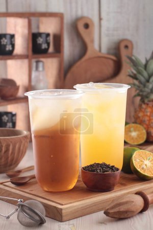 Téléchargez les photos : Un gros plan de deux verres de thé avec glace et citron sur une table en bois - en image libre de droit