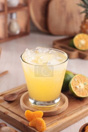 Téléchargez les photos : Verre de jus d'orange savoureux avec bâtonnets de cannelle sur la table - en image libre de droit