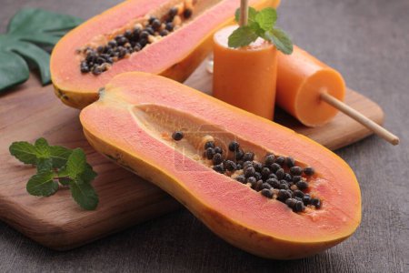 Téléchargez les photos : Fruits frais de papaye sur fond en bois - en image libre de droit