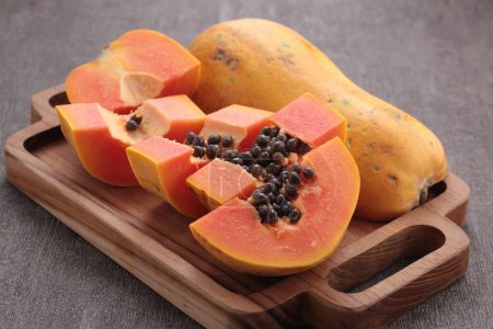 Téléchargez les photos : Papaye mûre tranchée sur planche à découper - en image libre de droit