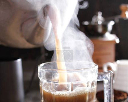 Téléchargez les photos : Verser le café dans un verre avec du lait - en image libre de droit